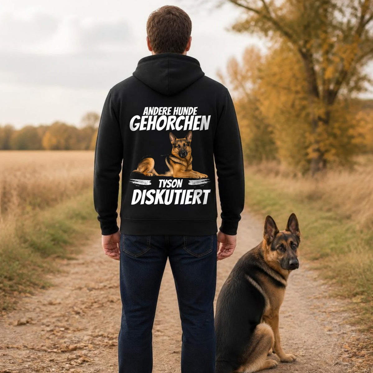 Mann im schwarzen Hoodie 'Andere Hunde gehorchen' auf Feldweg, Deutscher Schaeferhund sitzt daneben – personalisierter Hunde-Hoodie mit Foto und Name | Lil Snouts